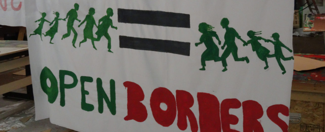 banner with text "climate justice = open borders"