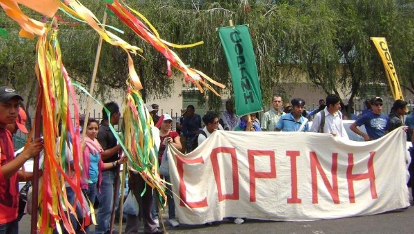 Members of COPINH holding a banner.