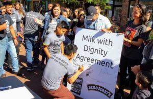 Dairy worker signing Milk With Dignity Pledge.