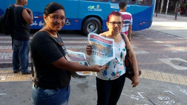 Women holding newspaper.